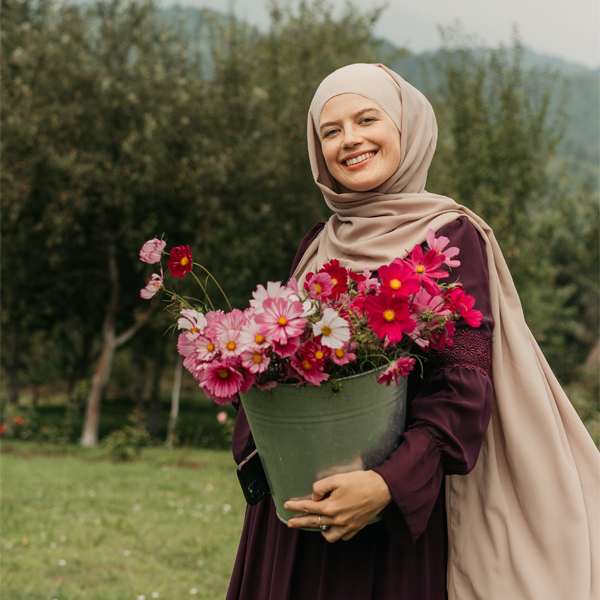 Melika Tursic Musinovic with a bucket of cosmos blooms