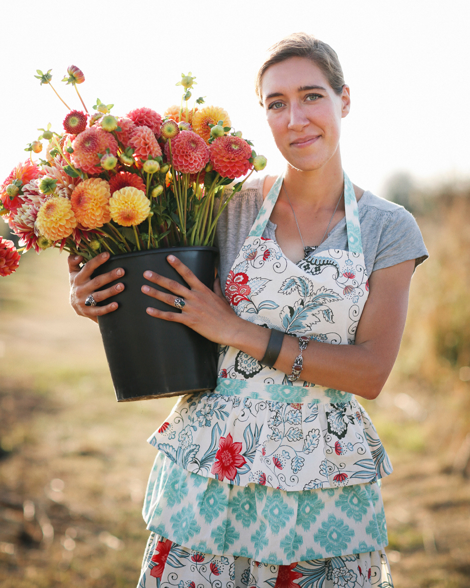 Erin Benzakein holding a bucket of dahlias